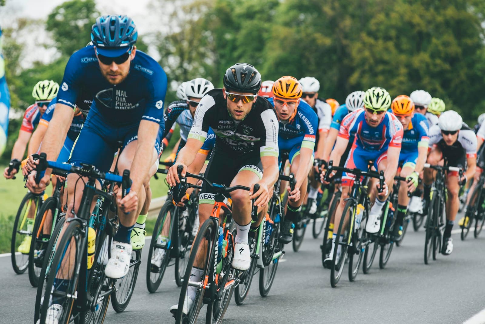 Tett peloton av landeveissyklister i full fart på asfaltvei