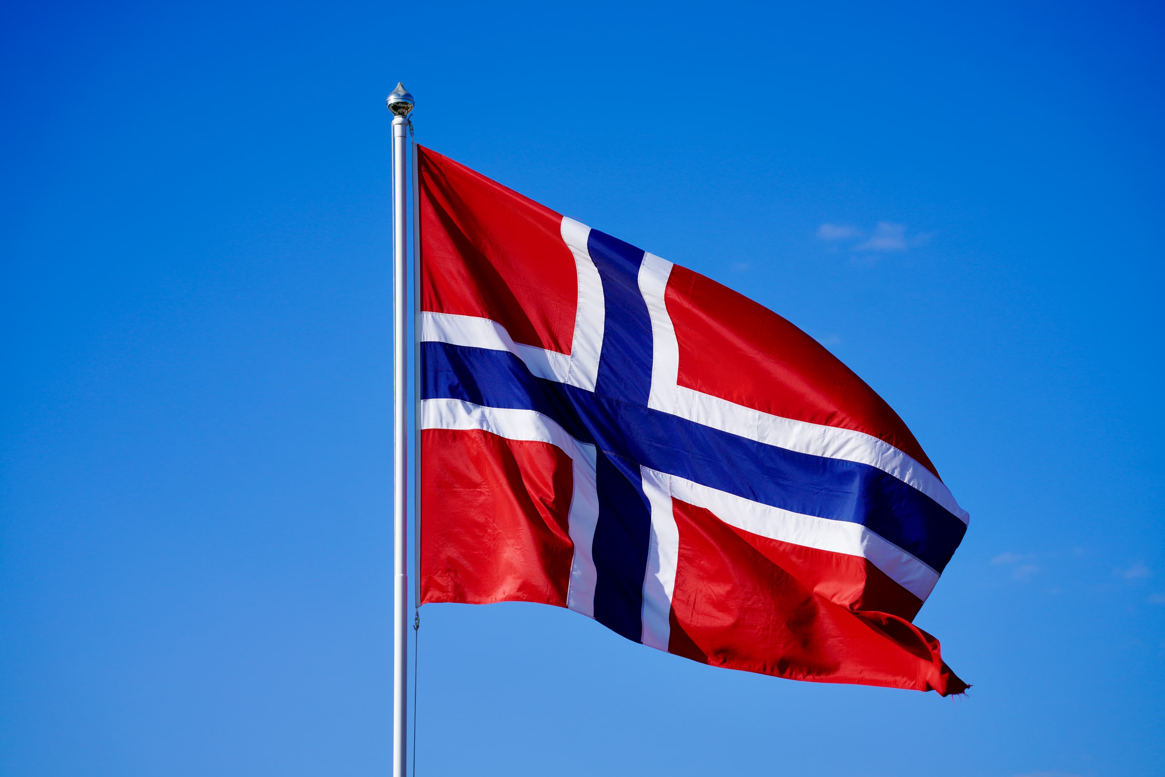 Norsk flagg mot blå himmel — illustrasjonsfoto